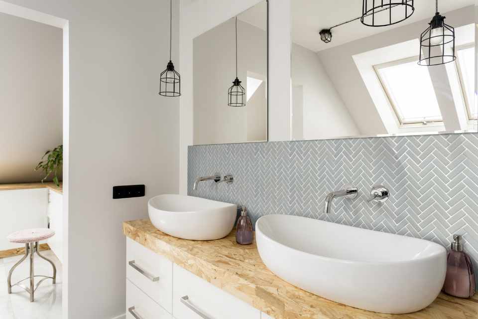 grey-blue tile inlaid in herringbone pattern as backsplash in contemporary bathroom with double sink